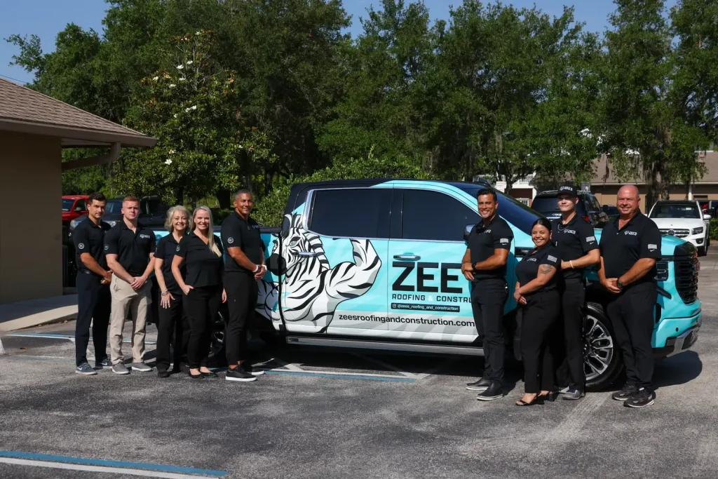 Zees Roofing and Construction team standing beside branded service truck in Sanford Florida